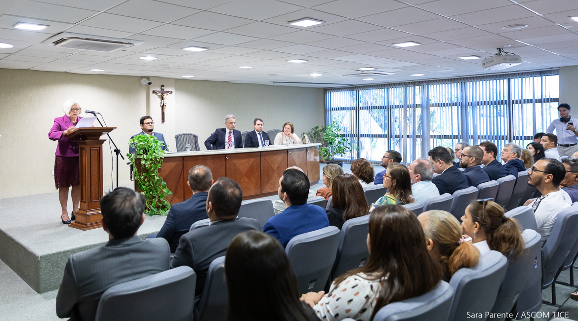 Foto do auditório com a mesa de autoridades e do público Foto do auditório com a mesa de autoridades e do público