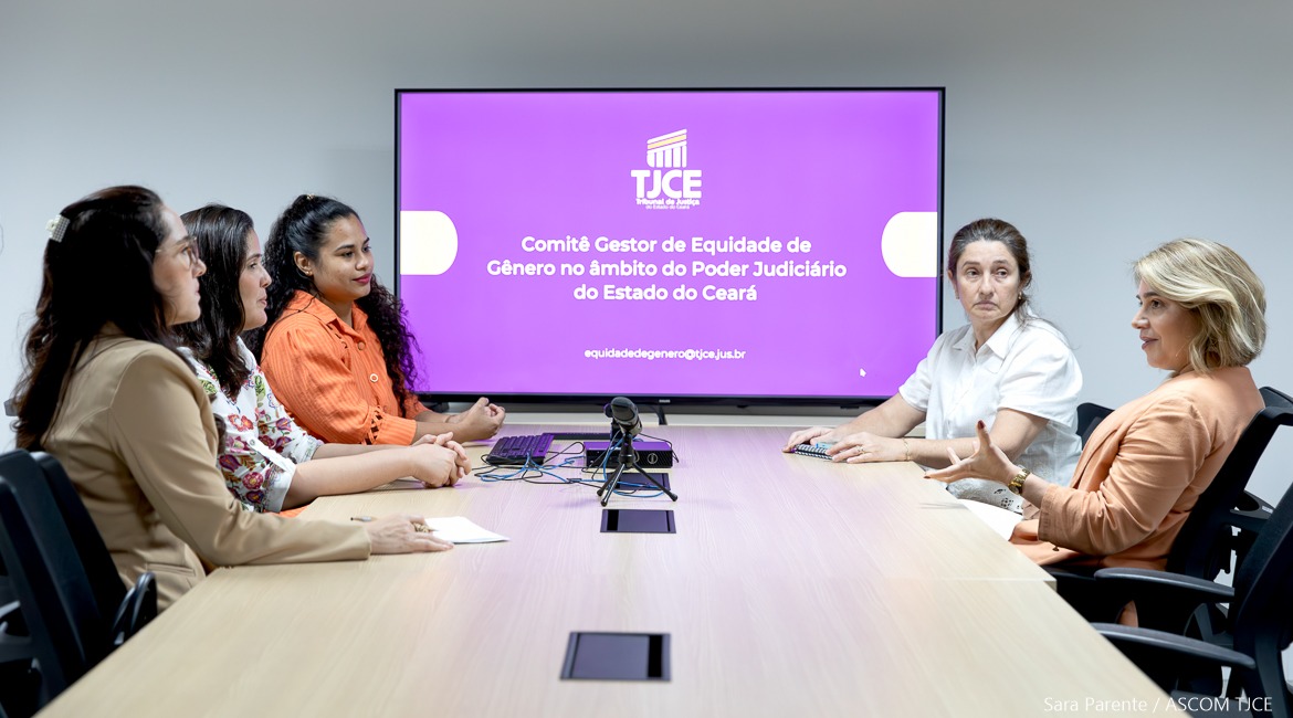 Foto com várias mulheres sentadas dialogando em uma mesa de trabalho Foto com várias mulheres sentadas dialogando em uma mesa de trabalho