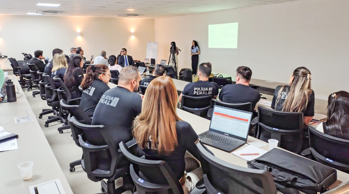Foto com várias pessoas sentadas dentro de uma sala durante uma explanação sobre o Plano