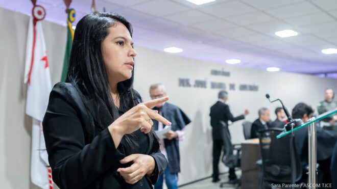 Moça gesticulando para interpretar em Libras Moça gesticulando para interpretar em Libras