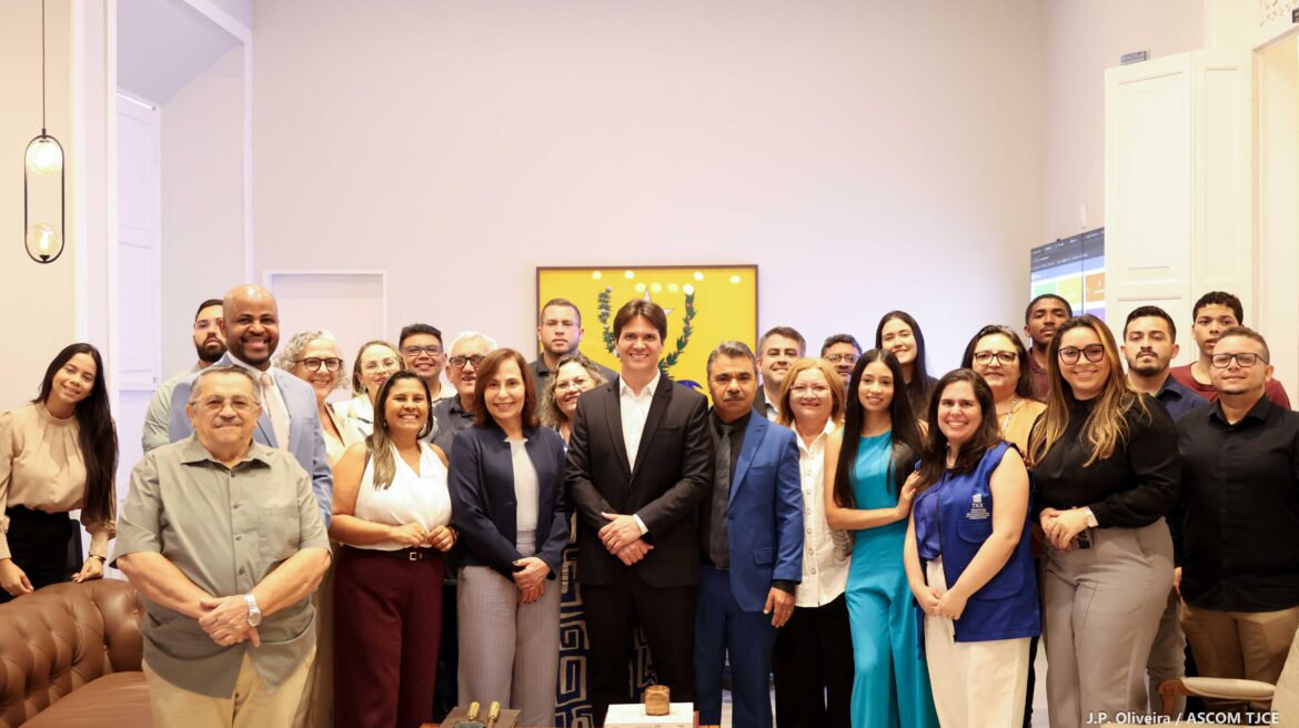 Vários homens e mulheres posam para foto 