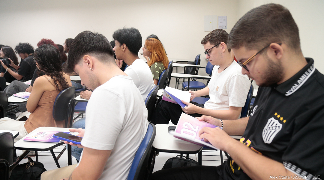 Estudantes do Centro Universitário Estácio conferem o material recebido Foto de estudantes em sala de aula