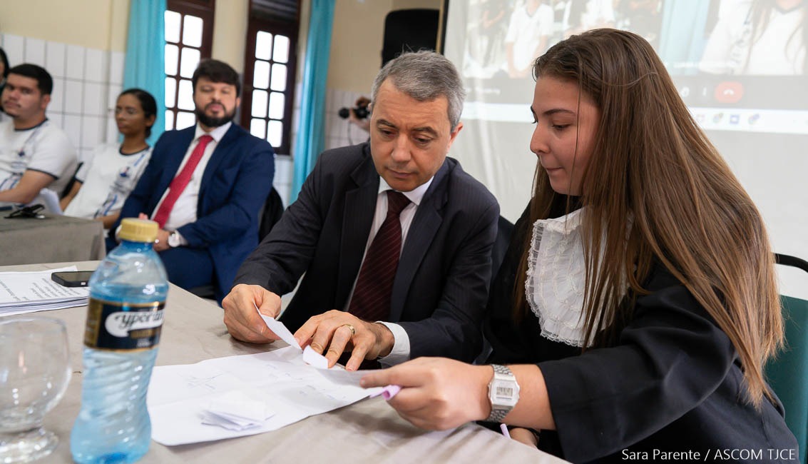 Foto de pessoas sentadas, observando informações escritas no papel Foto de pessoas sentadas, observando informações escritas no papel