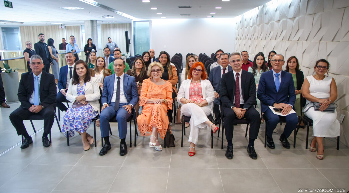 Imagem com mulheres e homens sentados durante o evento Imagem com mulheres e homens sentados durante o evento