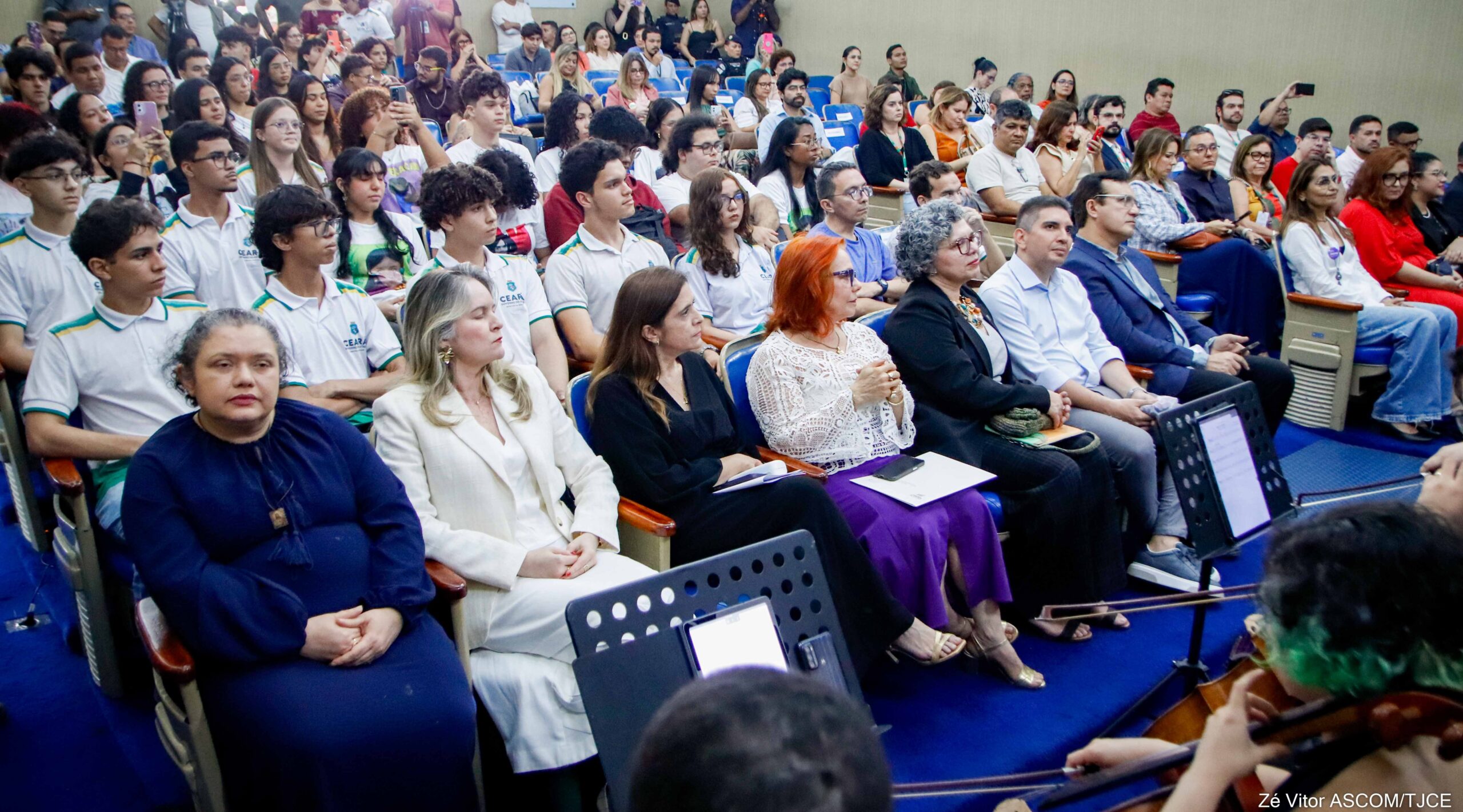 Auditório lotado de pessoas sentadas, vistas de frente, assistindo à cerimônia