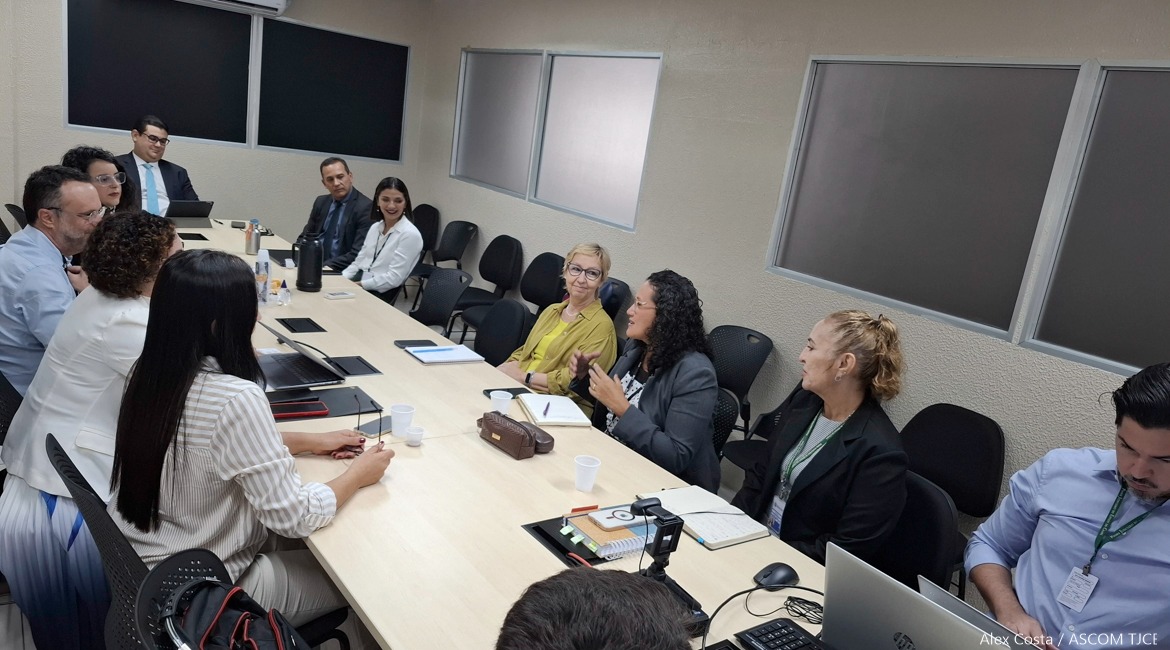 Uma mesa extensa com vários homens e mulheres sentados Uma mesa extensa com vários homens e mulheres sentados