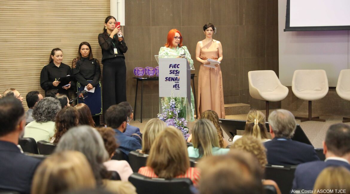 Mulheres no palco e várias pessoas na plateia Mulheres no palco e várias pessoas na plateia