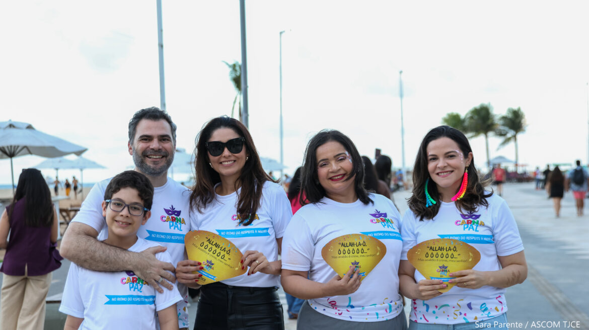 Três mulheres mostrando o material de divulgação, ao lado de um homem e uma criança