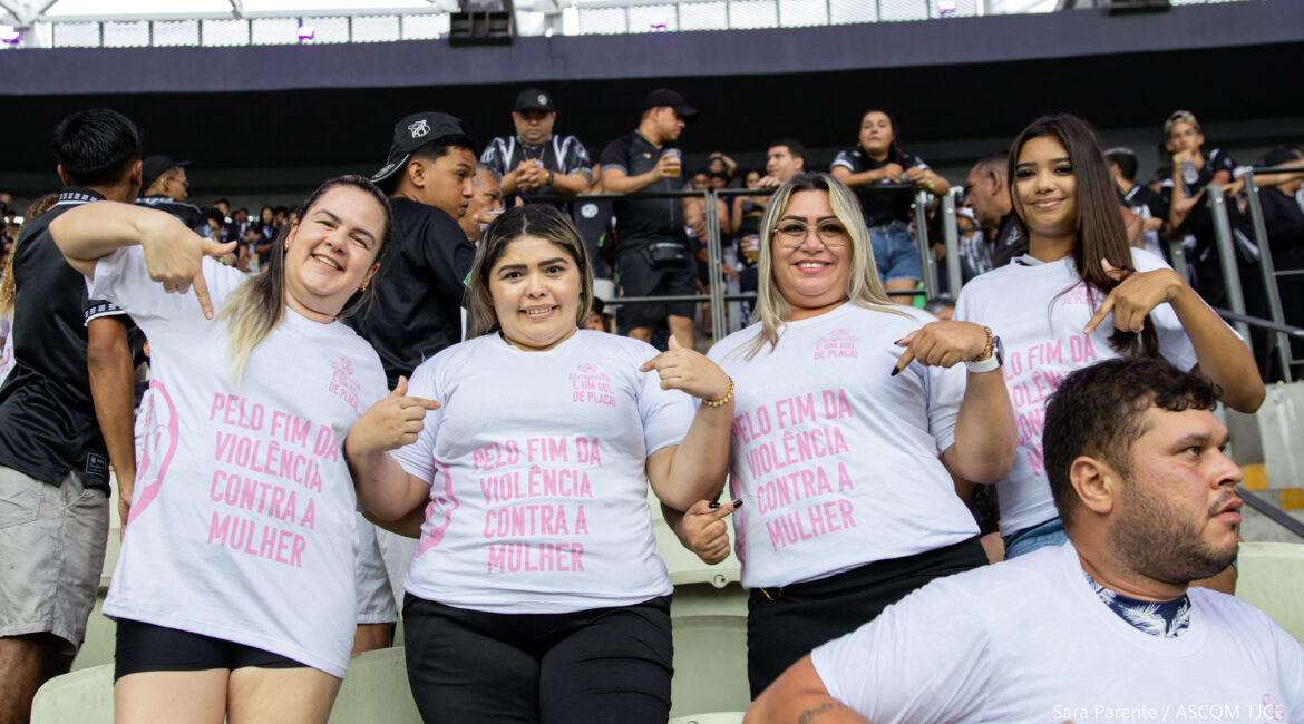 Quatro mulheres e um homem na arquibancada do estádio