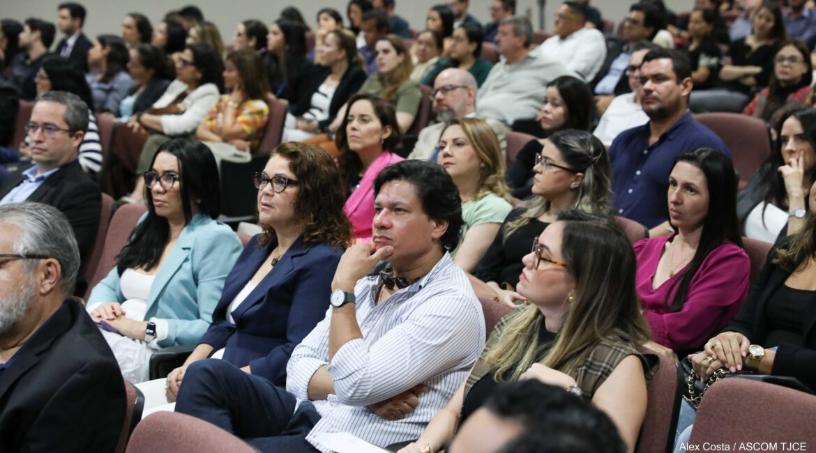 Foto com várias pessoas sentadas no auditório 