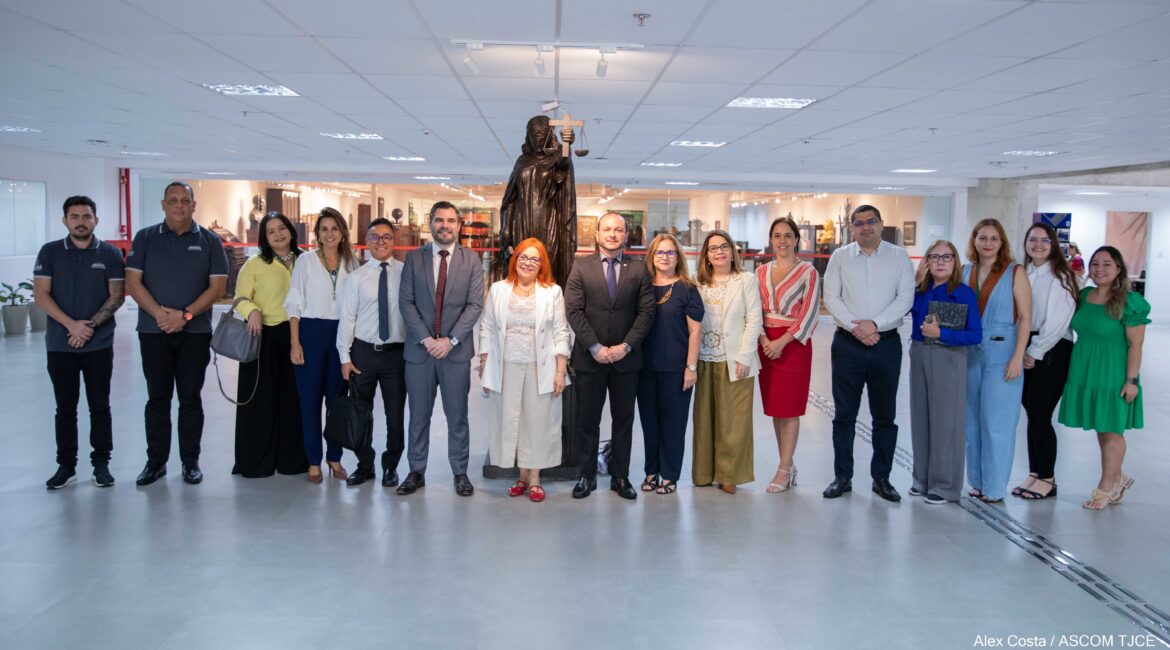 Várias mulheres e homens que posaram para foto, sorrindo, no hall do Tribunal ao final da reunião