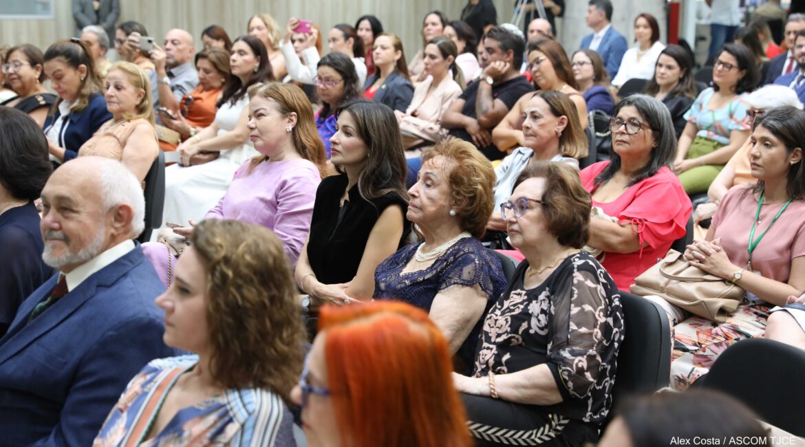 Foto, sendo a maioria composta por mulheres, sentadas no hall do Tribunal