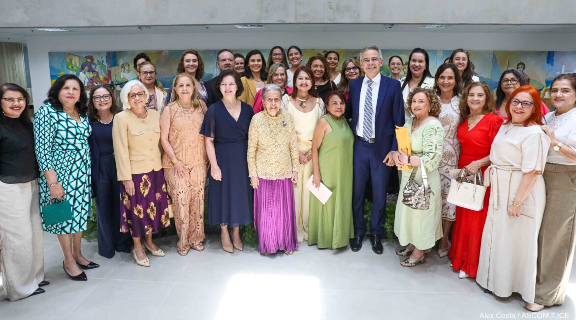 Imagem com várias mulheres e alguns homens, posando para foto, sorrindo