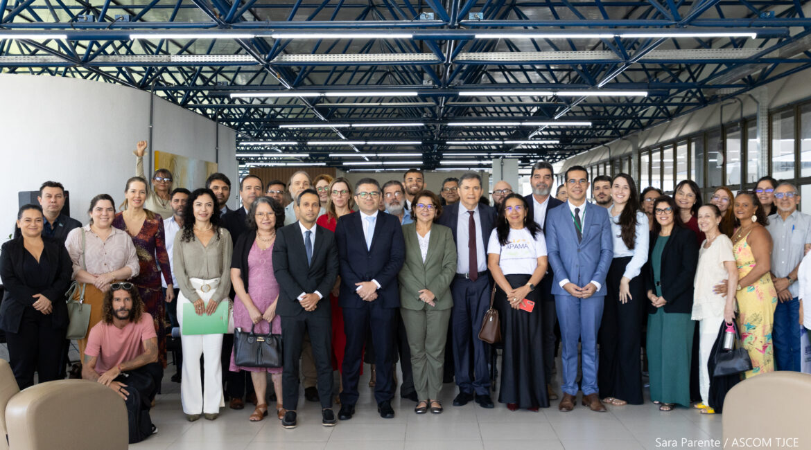 Imagem com várias mulheres e homens sorrindo posando para foto