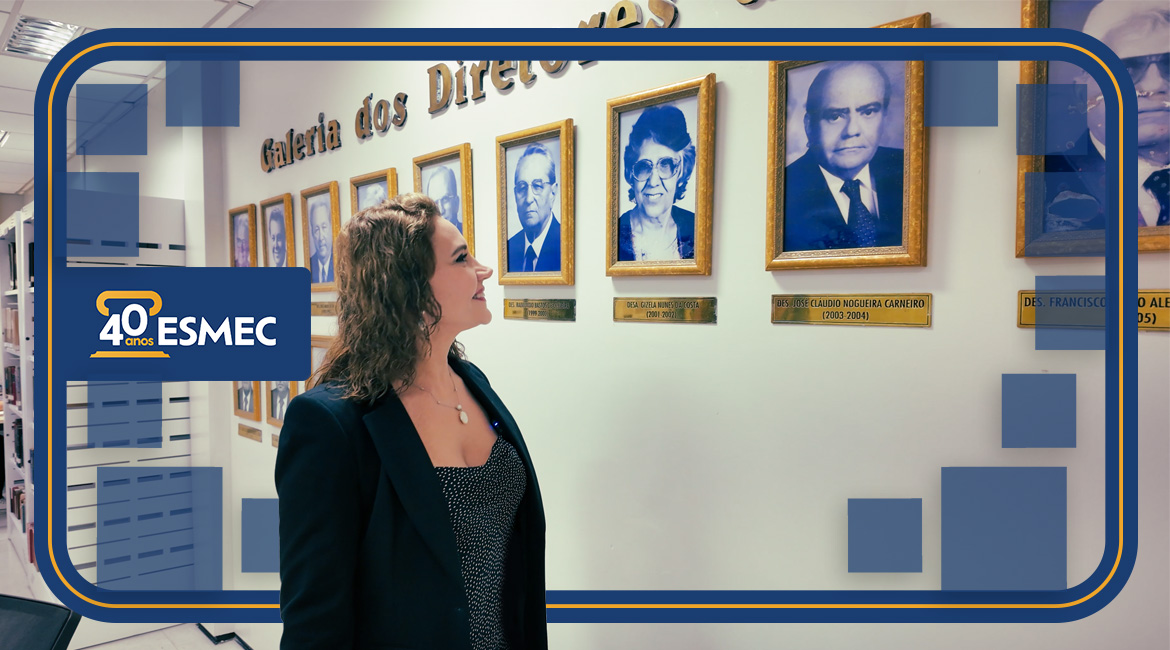 Foto de uma mulher olhando para uma galeria de fotos afixada na parede de uma sala