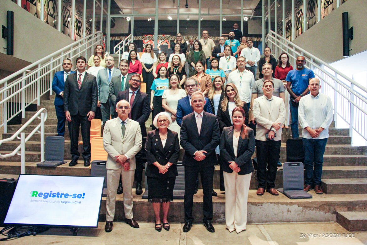 Imagem com várias mulheres e homens posando para foto, sorrindo, em uma escadaria