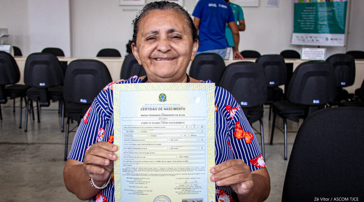 Foto de uma mulher sorrindo ao mostrar o seu documento