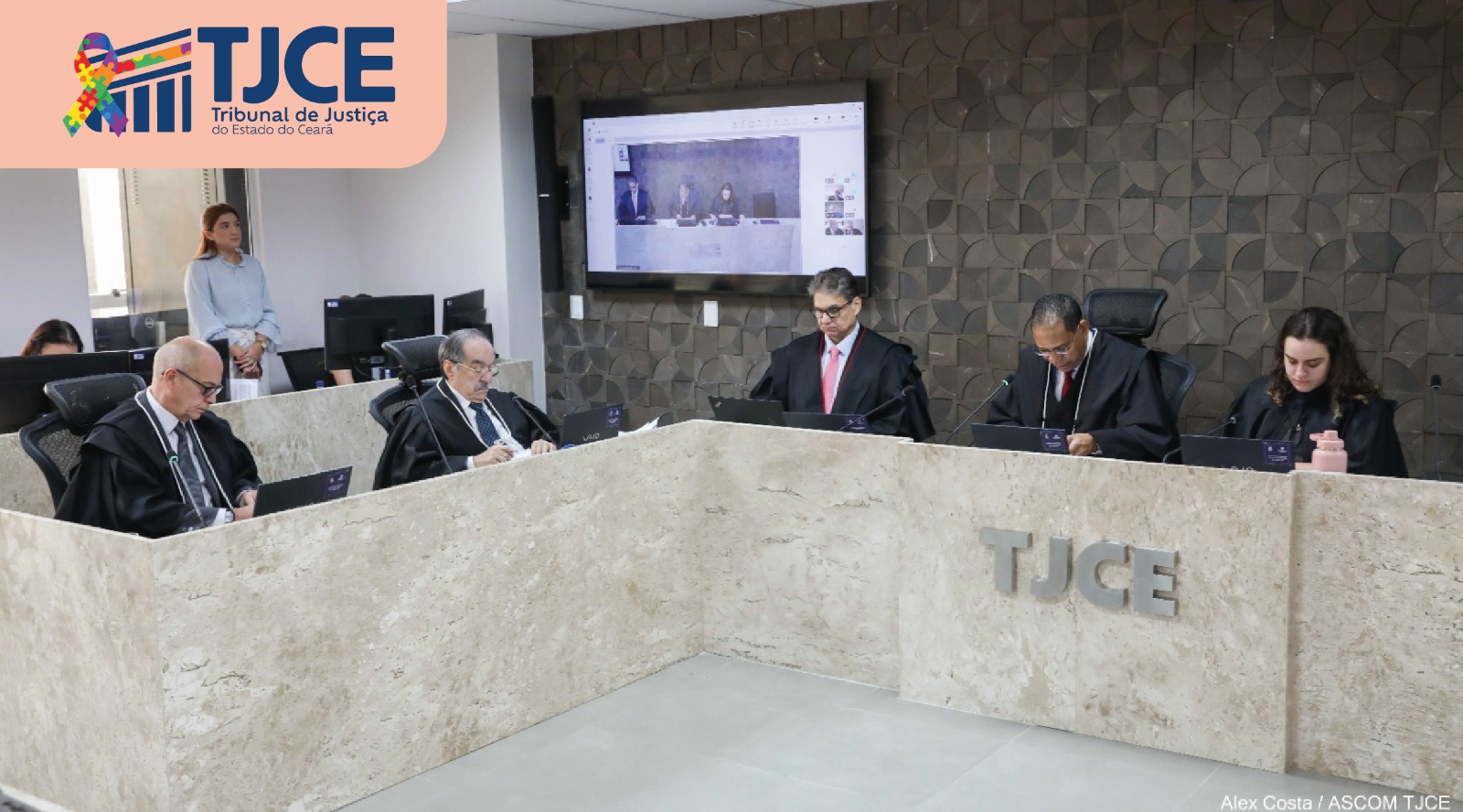 Foto de uma sessão de julgamento que se vê quatro homens e uma mulher sentadas(os), julgando processos