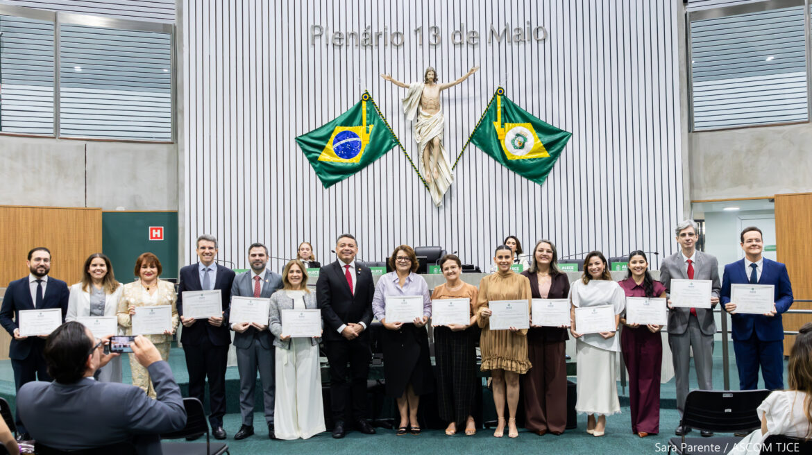 Uma filha de mulheres e homens posando para foto em pé, sorrindo, e exibindo um certificado Uma filha de mulheres e homens posando para foto em pé, sorrindo, e exibindo um certificado