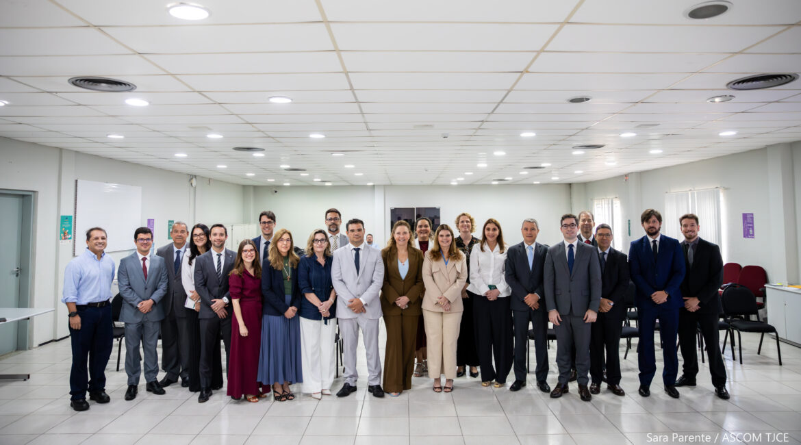 Imagem de várias mulheres e homens perfilhadas(os) posando para foto, sorrindo, em pé, no auditório Imagem de várias mulheres e homens perfilhadas(os) posando para foto, sorrindo, em pé, no auditório