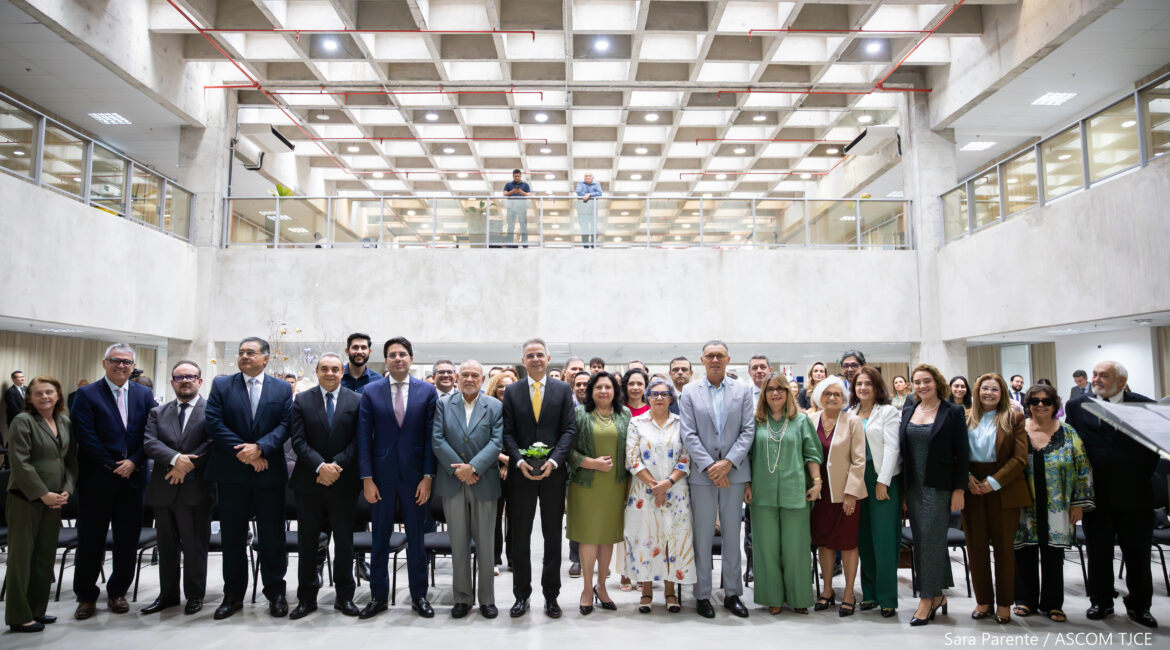 Vários homens e mulheres sorrindo para foto, em pé, no hall do Tribunal Vários homens e mulheres sorrindo para foto, em pé, no hall do Tribunal