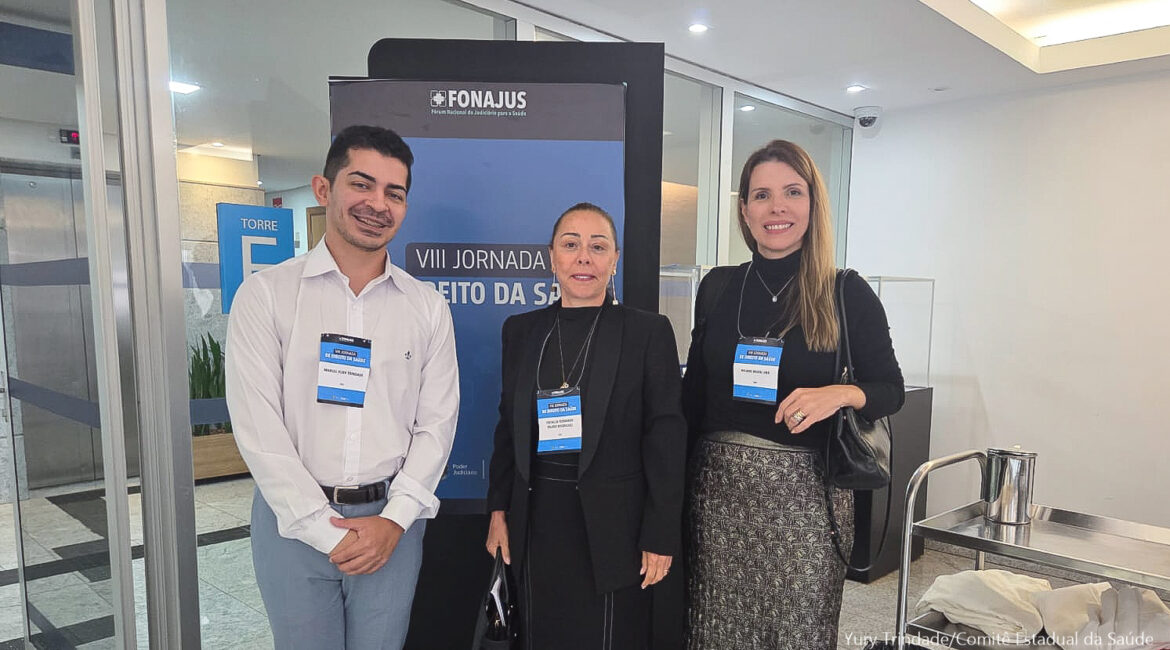 Imagem de um homem e duas mulheres posando para foto, sorrindo Imagem de um homem e duas mulheres posando para foto, sorrindo