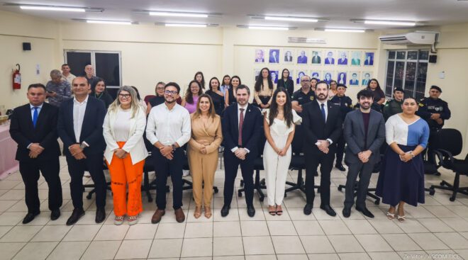 Pessoas enfileiradas, sorridentes, de pé, lado a lado, com algumas por trás.