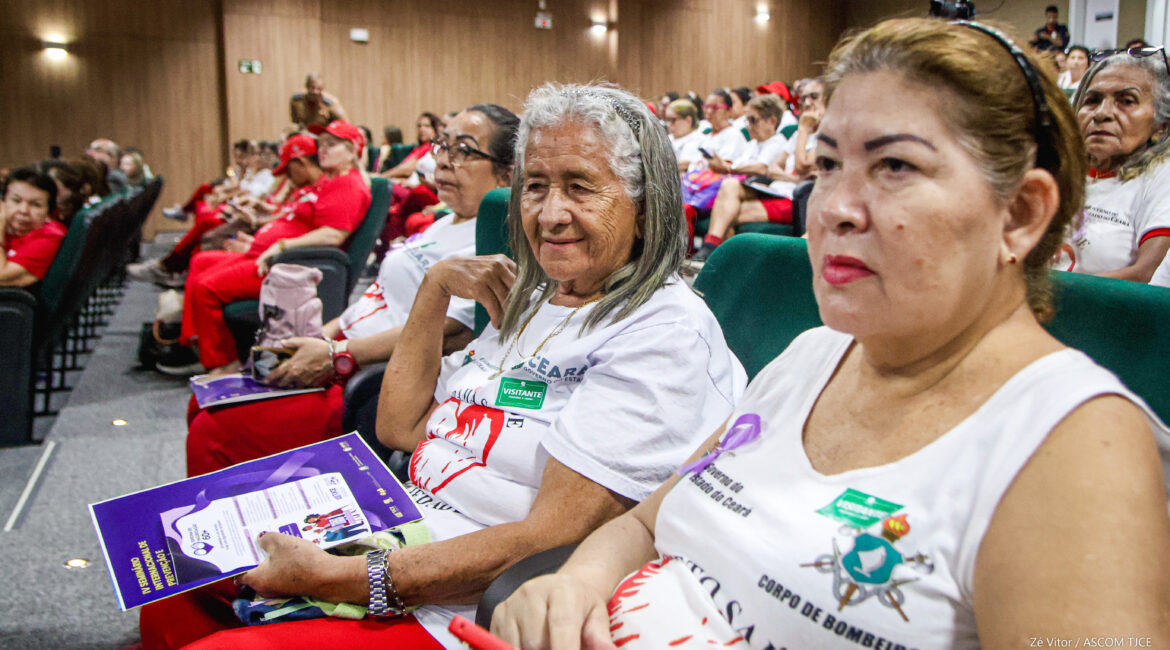 Foto que destaca o rosto de várias mulheres que estão sentadas no auditório