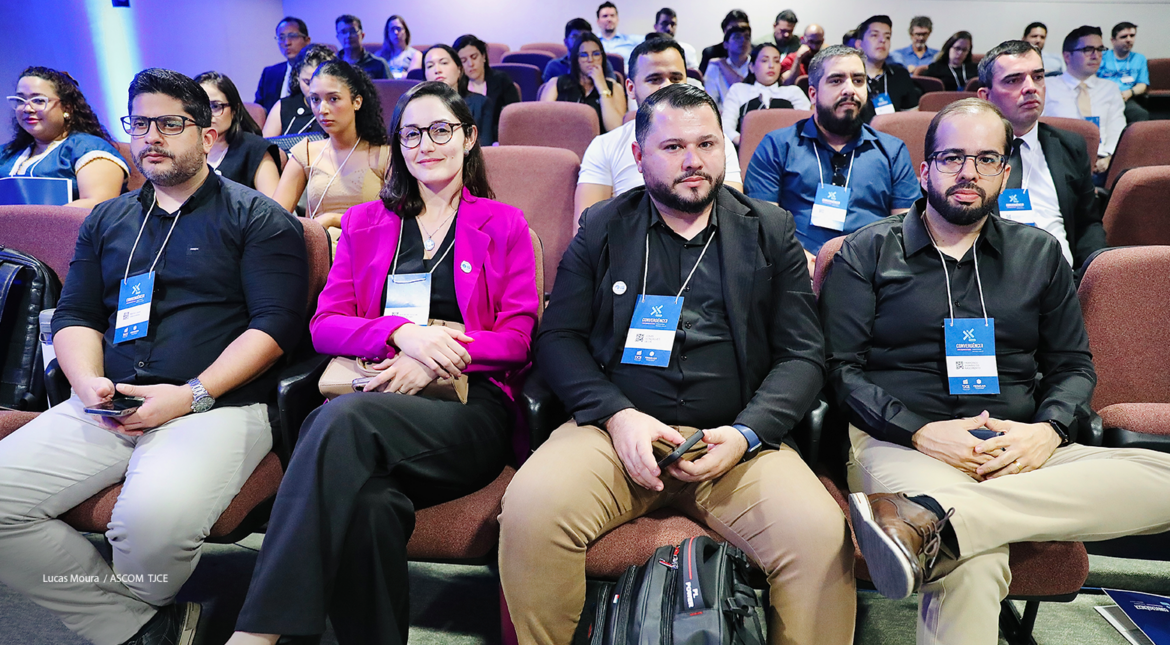 Imagem de mulheres e homens sentados em um grande auditório