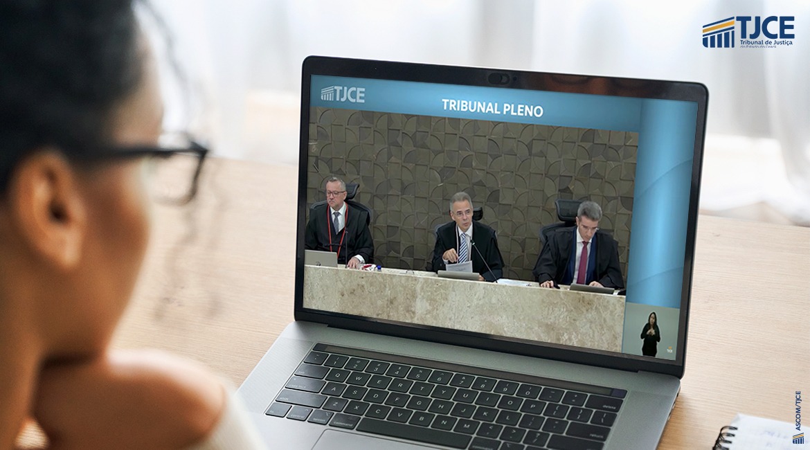 Acessibilidade de informações-1784225132 Uma mulher assiste pelo computador a uma sessão do Tribunal Pleno. No canto da tela, uma intérprete de Libras faz a tradução
