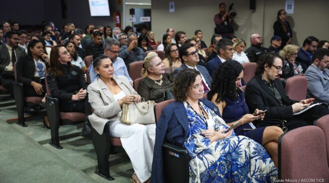 Pessoas sentadas em cadeiras de um auditório escutam apresentação do lançamento do CRV e Emprega Lab