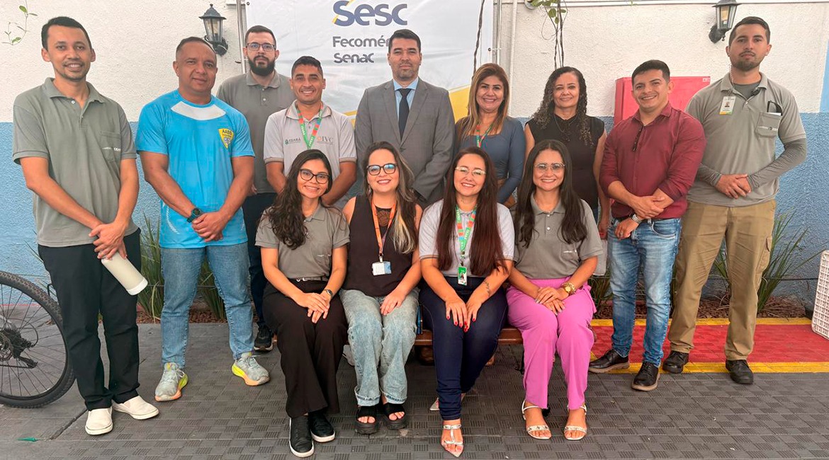 Imagem de várias pessoas posando para foto, sorrindo, em pé e sentadas