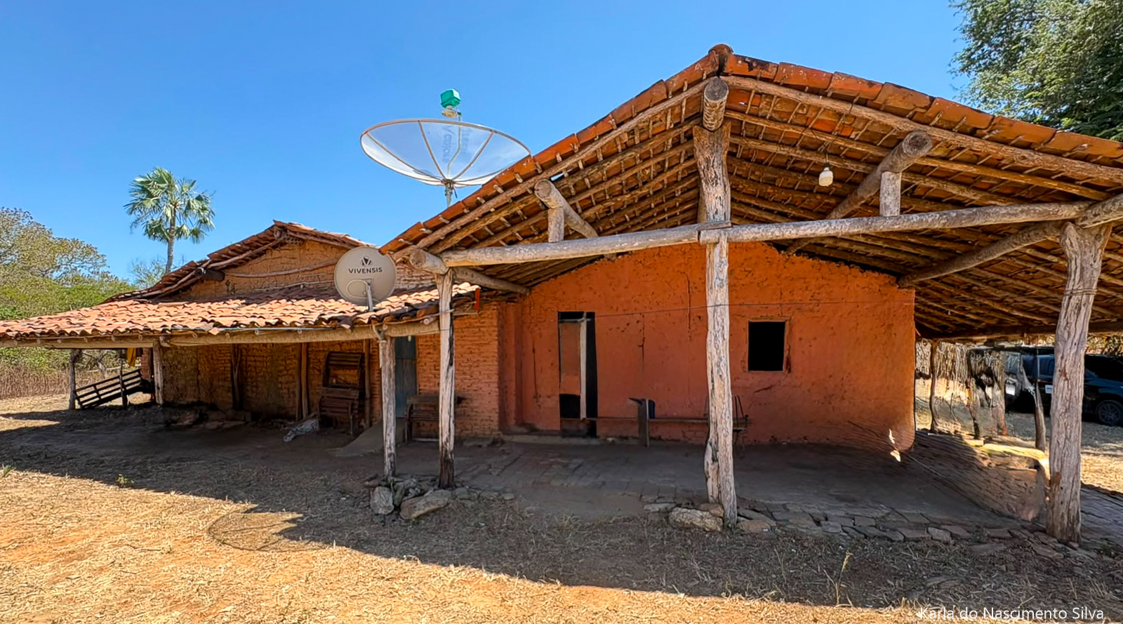 Imagem da fachada de uma casa de taipa, com varanda, no Interior