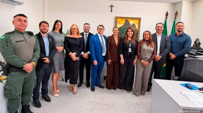 Fotografia de diversas pessoas sentadas em cadeias de plástico, formando uma plateia.