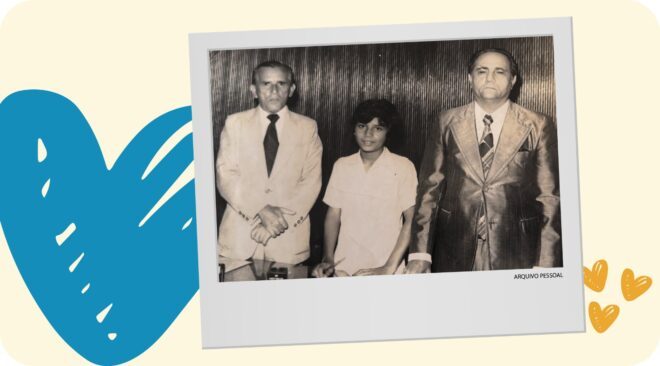 Foto em preto e branco, inserida como um post it, em um fundo amarelo bem claro, com um coração azul maior no lado esquerdo e pequenos corações amarelos escuros no canto inferior direito. Na imagem, um menino ladeado por dois homens de paletó.