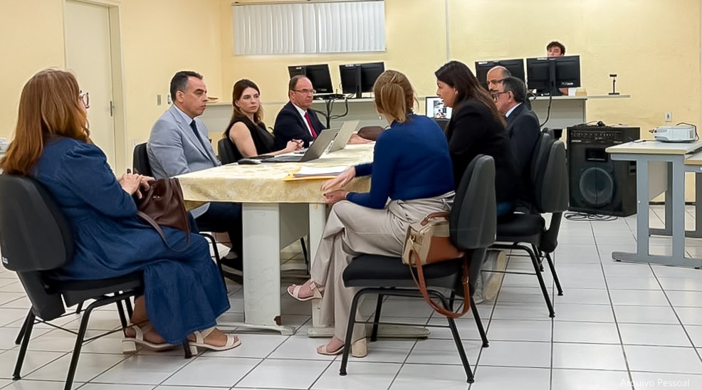 Foto de várias pessoas em uma mesa de reuniões.