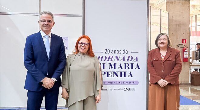 Duas mulheres e um homem posam sorridentes, lado a lado, para a fotografia.