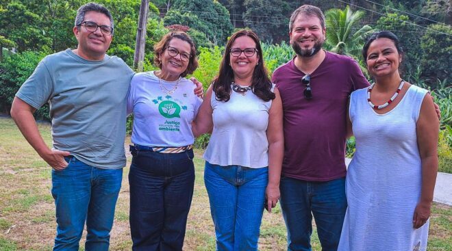 Cinco pessoas sorridentes posam para foto
