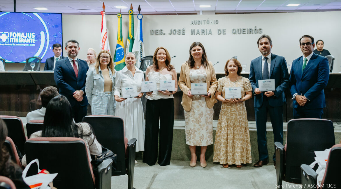Imagem de três homens e cinco mulheres que posam para foto, em pé, exibindo os certificados de reconhecimento