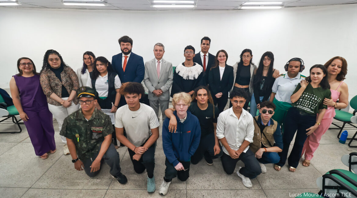 Imagem de várias pessoas em pé e agachadas, sorrindo para foto, após o encerramento do evento